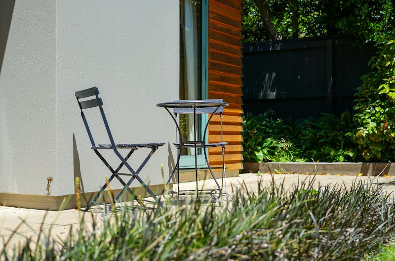 Two chairs and a table on an outdoor concrete patio